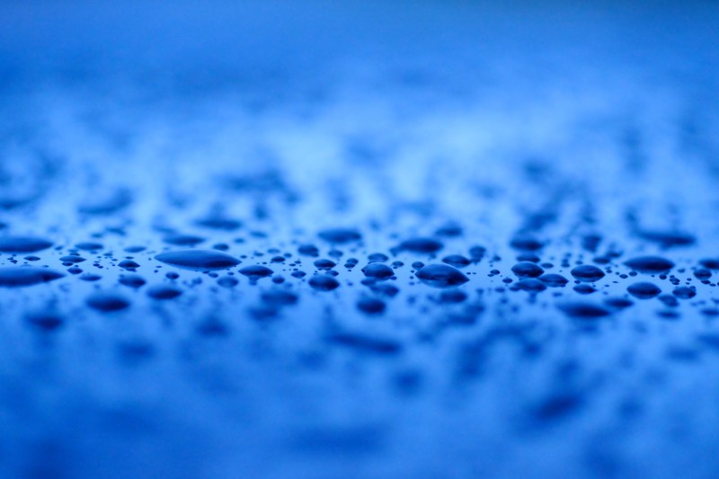Close-up of raindrops on blue surface