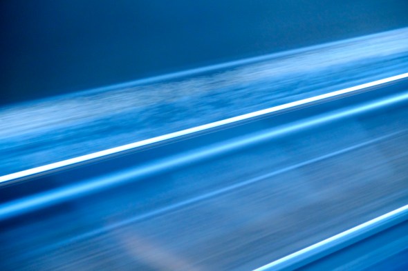 Abstract view in blue of moving railroad tracks