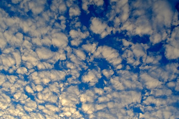 white cottony clouds interspersed in deep blue sky
