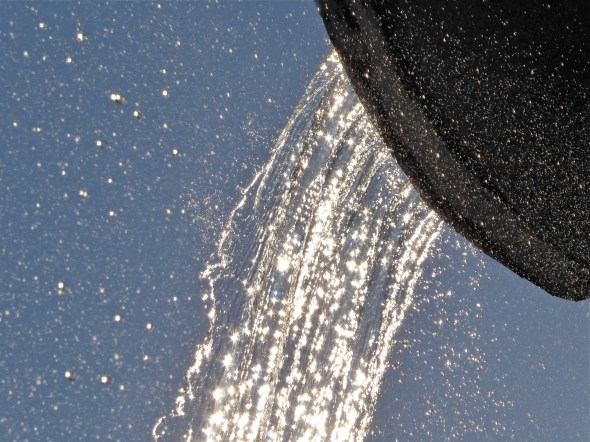 Water full of sunbursts cascading from fountain