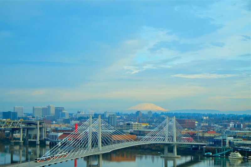 Portland, OR, Willamette River, Tilikum Crossing bridge and Mt. St. Helens on partly cloudy winter day