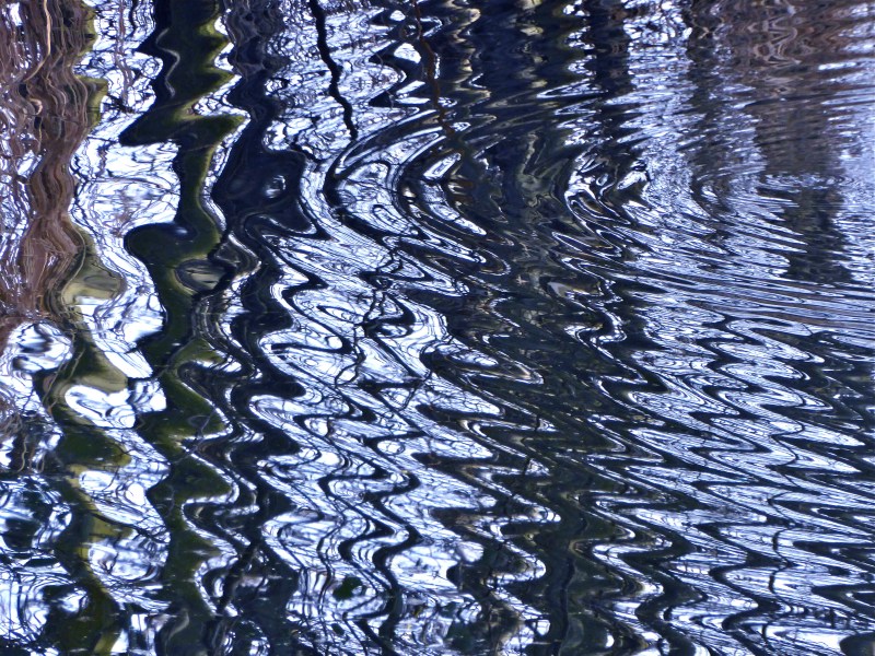 Wavy light and dark rippled reflections in marsh