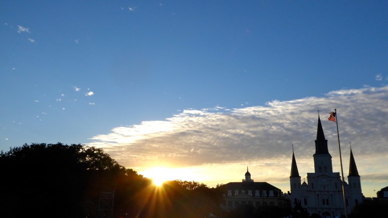 Sunset silhouette of Historic Catholic Church, American flag and trees
