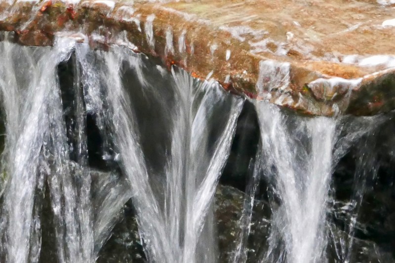 Water falling from small stone ledge