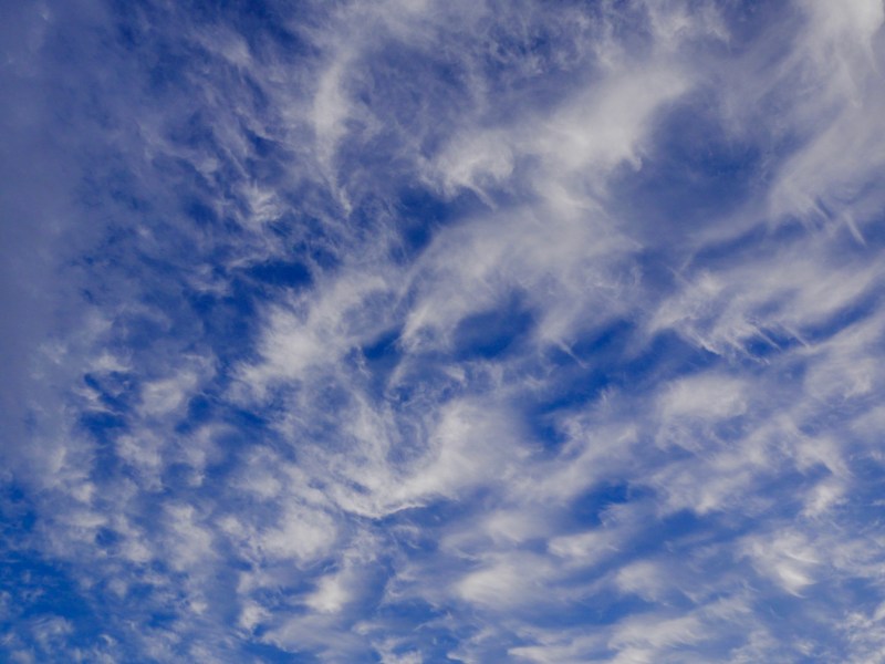 Curly high clouds in deep blue sky