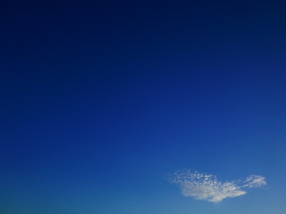Deep blue sky with a few feathery white clouds