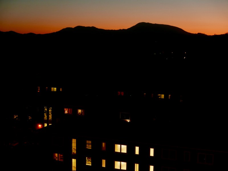 Silhouette of dark mountains against orange-tinted sky