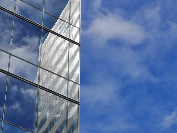 Blue sky and reflection of sky and skyscraper in another skyscraper