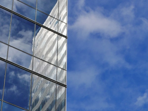 Blue sky and reflection of sky and skyscraper in another skyscraper