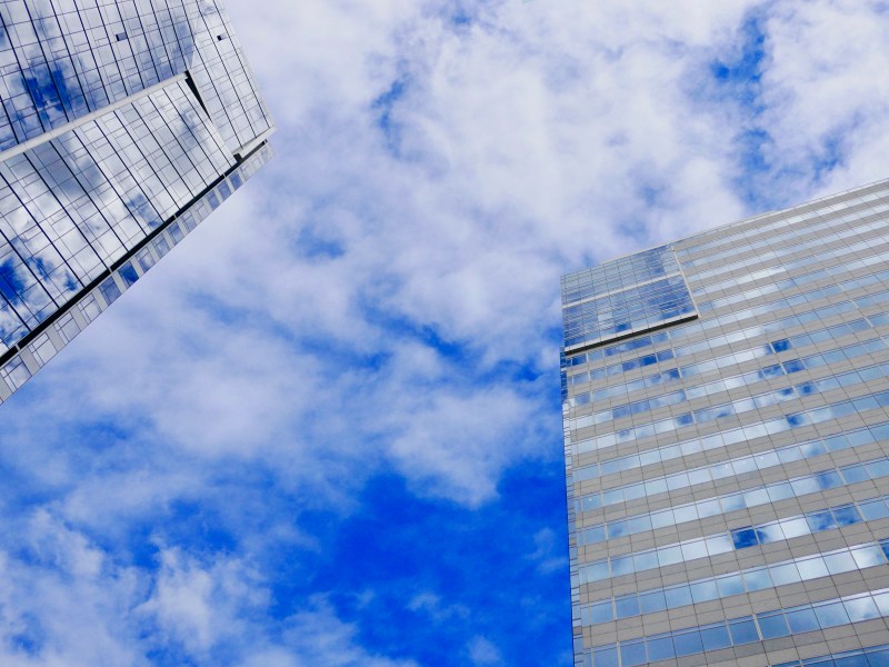 Two skyscrapers and blue sky with white clouds