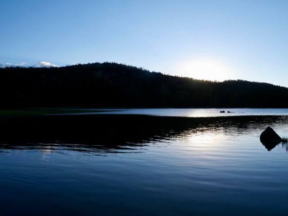 Blue lake and silhouetted hills at sunset