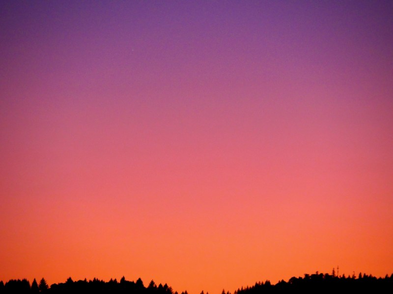 Glowing pastel sky over silhouetted horizon