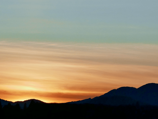Silhouetted mountains and orange sky