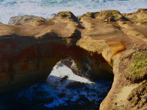 Ocean flowing through natural rock arch