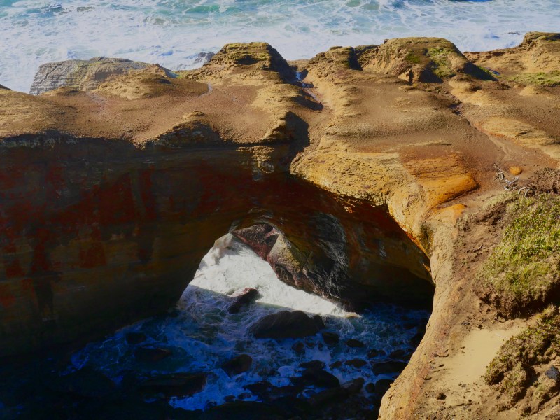 Ocean flowing through natural rock arch