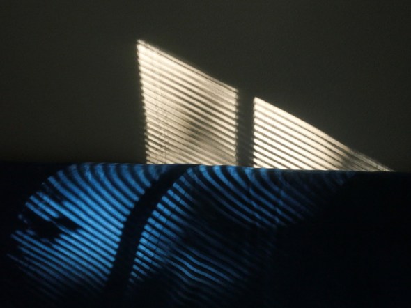 Shadows of blinds on futon and wall
