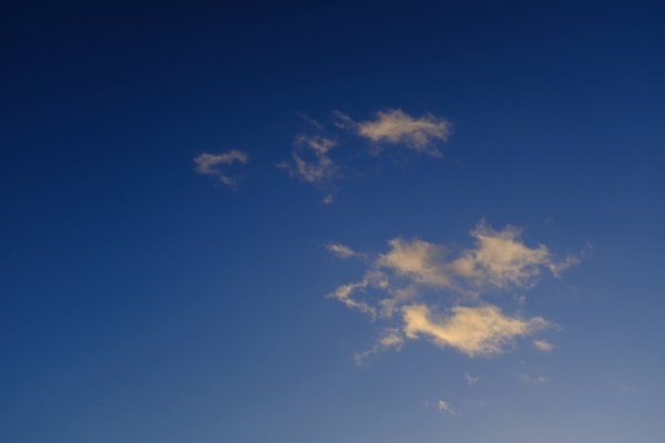 Small white clouds in blue sky