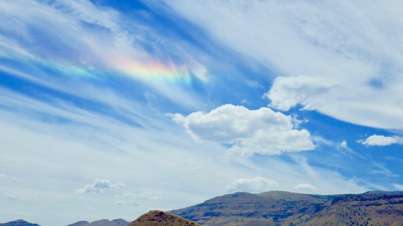 hilly, dry landscape with iridescent clouds in sky