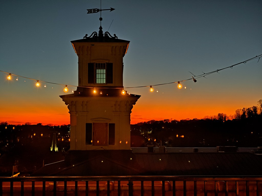 top of courthouse with weather vane and orange glowing sky