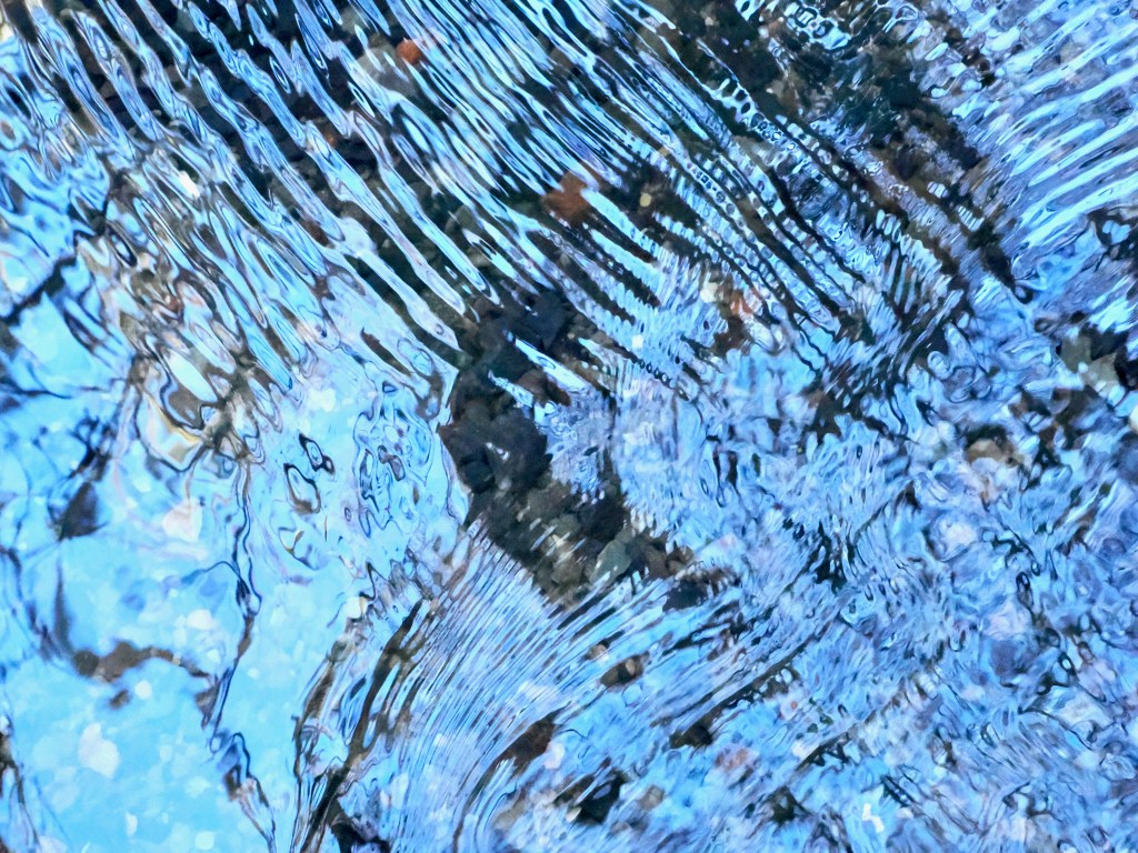 tiny ripples and blue reflections in small creek