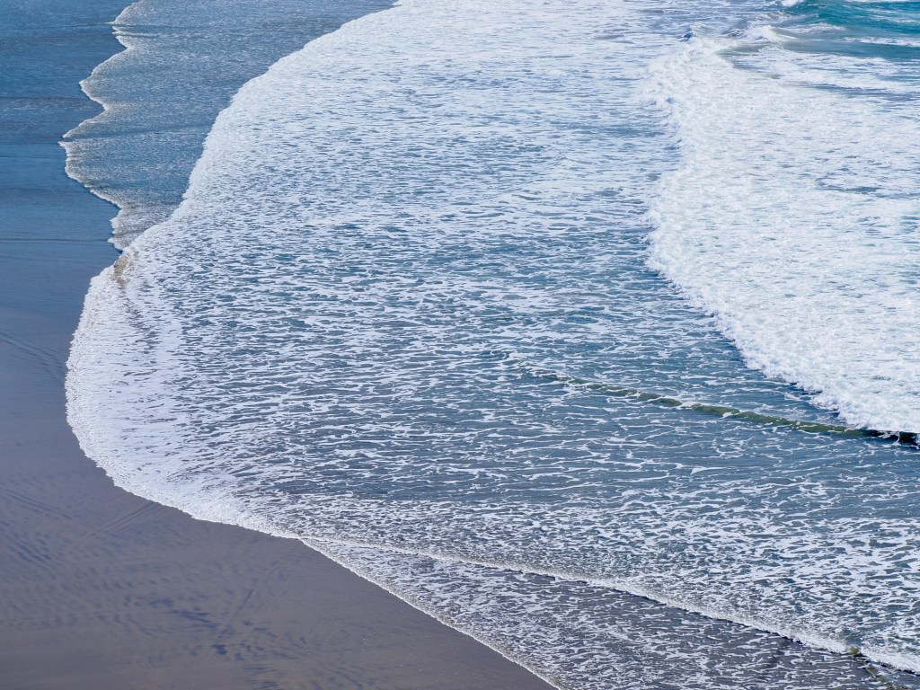 calm surf running up on sandy beach
