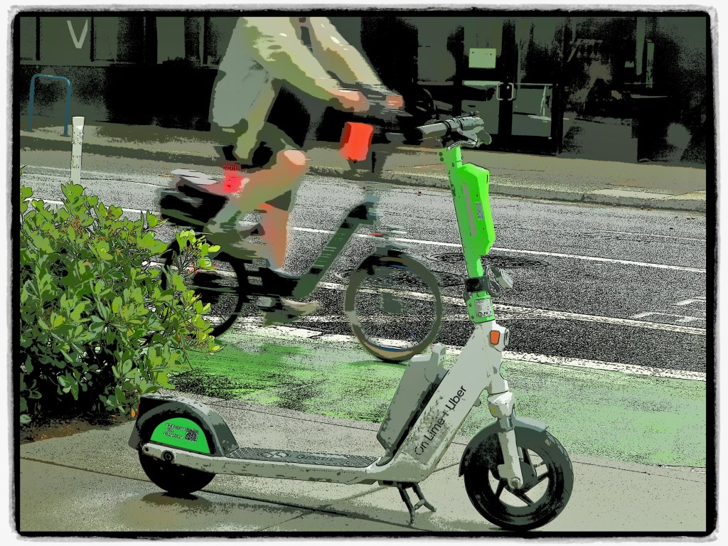 scooter and moving biker on city street